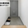 靴箱のない団地の狭い玄関に靴を4足だけそろえて置いた様子